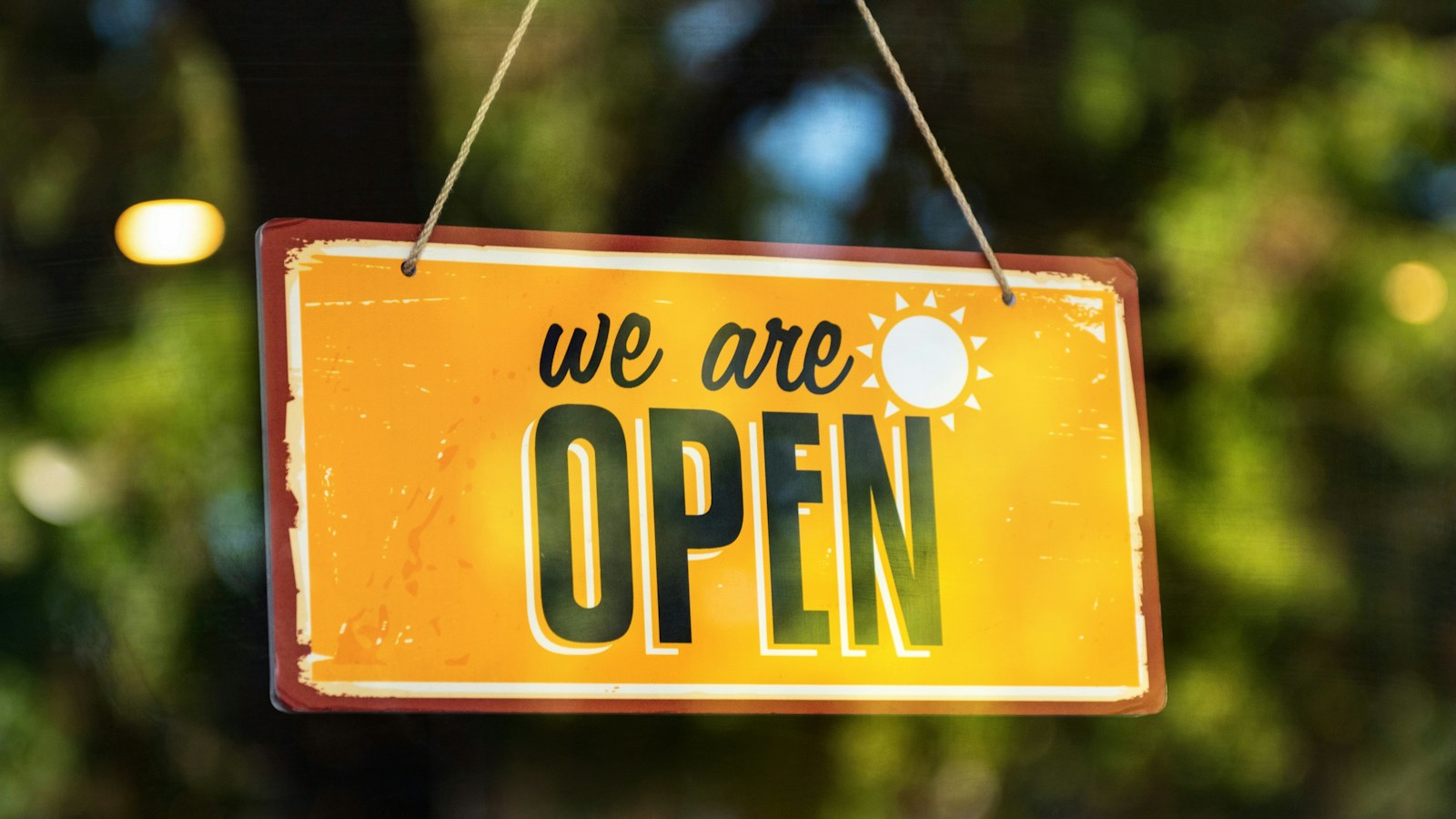 店の入口にかかった「WE ARE OPEN」の黄色い札