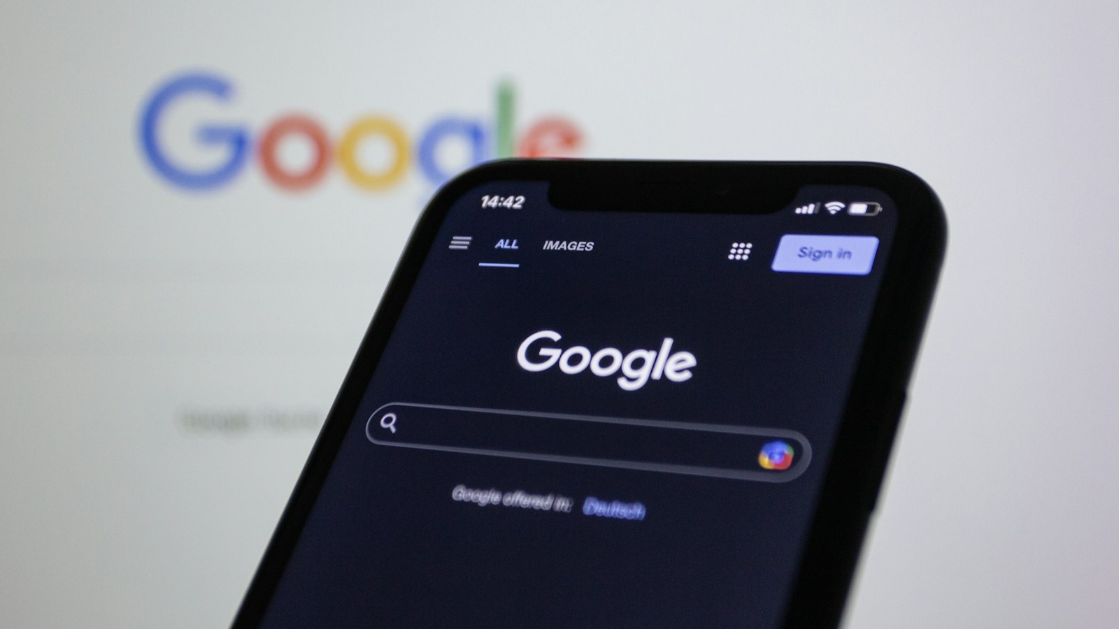Googleのロゴを背景にしたスマートフォン